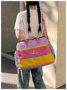 Detailansicht der bunten Reisetasche mit mehreren Reißverschlusstaschen und Schultergurt.