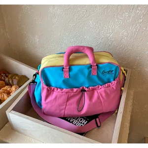 Nahaufnahme der bunten Reisetasche mit Griffen, Umhängegurt und Fronttasche im Lifestyle-Szenario