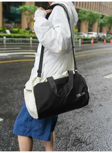 Detail view of the black and white nylon sports travel bag, showing texture and outdoor use.