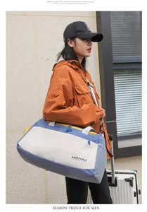 Detailed view of the stylish blue and white travel duffel bag carried by the model.