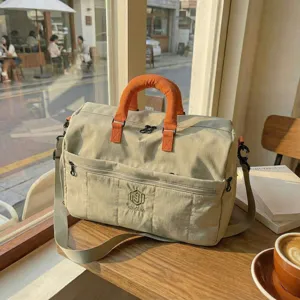 Casual large travel duffel bag with orange handles, spacious gym bag and luggage organizer for trips.