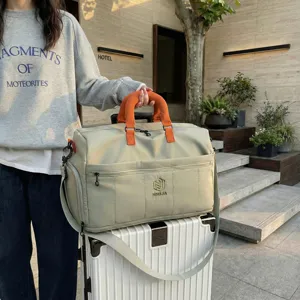 Large capacity travel duffel bag with stylish orange handles, lightweight and expandable.