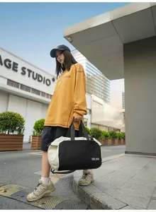 Outdoor travel fitness duffel bag in black and white nylon, scene display with model.