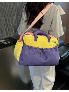 Farbblock-Reisetasche mit Schultergurt und geräumigem Fach für Fitness und Sportaktivitäten.