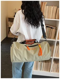 Detail view of large canvas travel duffel bag with braided handle and side pocket.