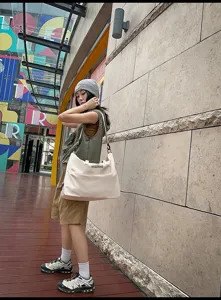 Outdoor lifestyle detail view showcasing the large waterproof nylon shoulder bag in white.