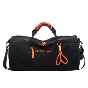 Black gym duffel bag with vibrant orange paracord handles for sports and travel use.