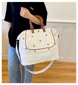 Large capacity canvas travel weekender bag with cute bow embroidery, brown handles and strap.