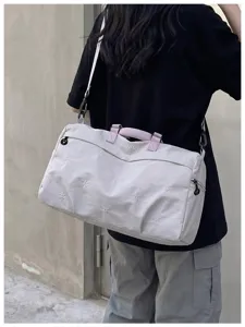 Detail view of the lightweight travel duffle bag with embroidery patterns and handles.