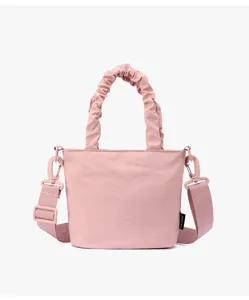 Vue détaillée du charmant sac seau en toile rose avec poignées froncées et sangle.