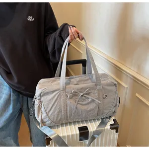 Detail view of large capacity travel duffel bag with bow design and trolley sleeve.