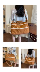 Detail view of the brown travel duffel bag with lace trim, showing storage and shoulder strap.