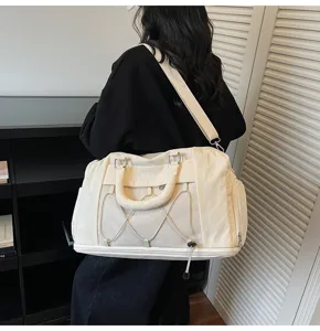 Detail view of a large capacity cream white fitness travel duffel bag with strap.