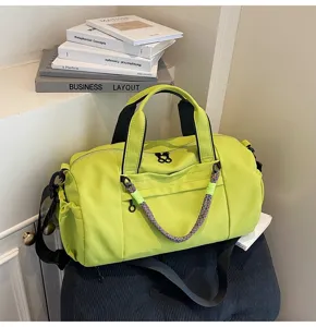 Detalle de la bolsa de viaje verde neón con asas resistentes, cremalleras y correa de colores.