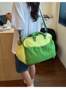 Detailansicht der großen, farblich abgesetzten Reisetasche mit Schultergurt und Fronttasche.