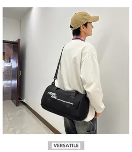 Detail view of the black cylindrical sports gym bag worn on shoulder, showing large capacity.