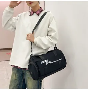 Detail view of black cylindrical sports duffel bag with shoulder strap and large capacity.