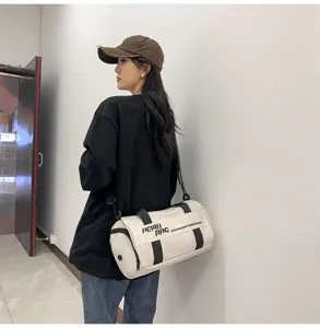 Cylindrical gym duffel bag for sports and travel, spacious capacity with shoulder strap.