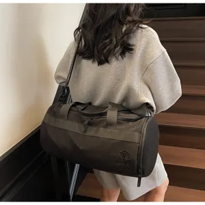 Detailansicht der großen schwarzen zylindrischen Sporttasche mit Schultergurt und Netztasche.