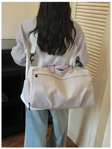 Detailed view of lightweight travel duffel bag with spacious interior and pink handles.