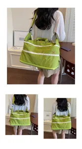 Detail view of the green travel duffel bag with cute bow embroidery and lace trim on model.