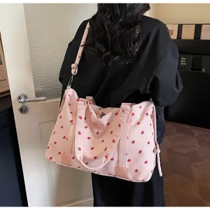Pink corduroy travel duffel bag with cute strawberry print, details and straps.