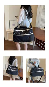 Stylish black travel bag with elegant lace trim and cute blue embroidery for daily use.