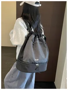 Sac à dos étanche à cordon avec motif à carreaux et compartiment inférieur pour le sport.