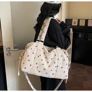 Detailed view of the large-capacity corduroy travel bag with cute strawberry print and straps.