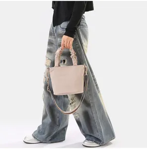 Sac seau en tissu uni minimaliste avec poignée froncée élégante et bandoulière réglable.