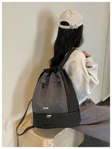 Vue de détail d'un élégant sac à dos étanche avec motif à carreaux et compartiment bas.
