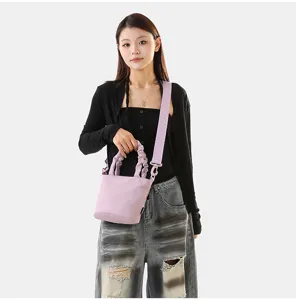 Vue détaillée d'un élégant sac seau en toile mauve clair avec poignée froncée et sangle.