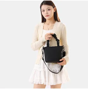Vue détaillée du sac seau bandoulière en tissu uni minimaliste, style quotidien chic.
