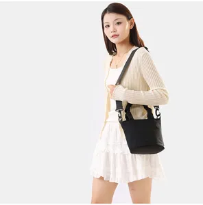 Vue détaillée du sac seau en toile noire avec bandoulière réglable style quotidien.
