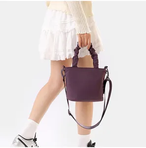 Vue détaillée d'un sac seau bandoulière violet tendance avec poignées froncées et sangle.