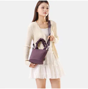 Vue détaillée d'un sac seau en tissu violet tendance avec poignée froncée et sangle.
