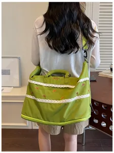 Detailed view of the green travel gym bag featuring cute lace trim and embroidered details.