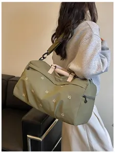 Olive green travel duffle bag detail showcasing embroidery, durable handles, and large capacity.