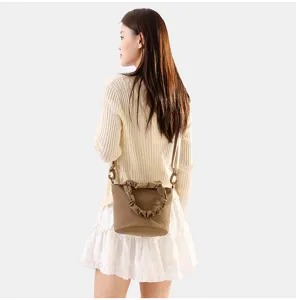 Detail de sac seau bandouliere en toile unie minimaliste, design tendance et décontracté.