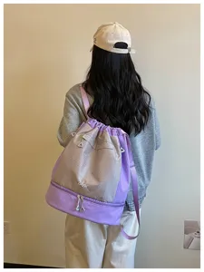 Vue détaillée du sac à dos de sport violet et gris à cordon avec compartiments fonctionnels.