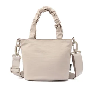 Sac seau bandoulière uni et minimaliste avec poignée froncée et sangle réglable.