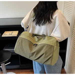 Detailaufnahme der großen grünen Reisetasche mit Schultergurt und praktischen Seitentaschen.