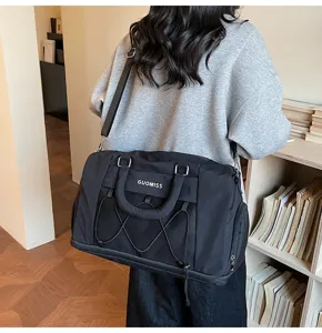 Detailed view of the large capacity black travel gym bag with mesh pocket and shoulder strap.