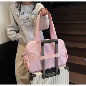 Detailansicht der rosa Reisetasche mit wasserdichtem Material und praktischem Kofferband.