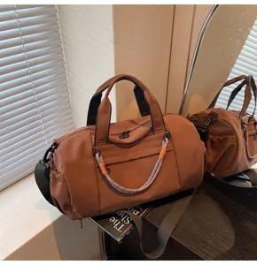Detalle de bolsa de viaje marrón que muestra la textura de tela duradera y asas elegantes.