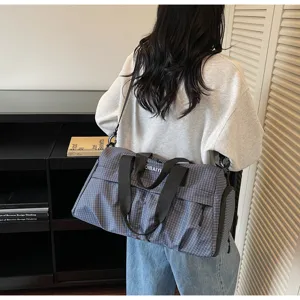 Grand sac de sport à carreaux pour voyage fitness et déplacements avec bandoulières.