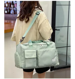 Detailed view of large capacity light green gym duffel bag with multi pockets and shoulder strap.
