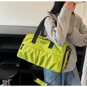 Grand sac de voyage vert à motifs quadrillés avec bandoulière pour le sport et les voyages.