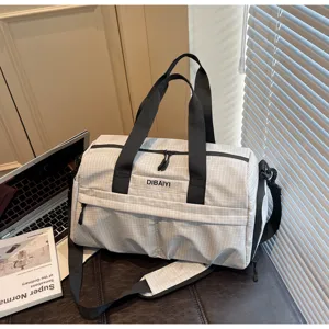 Vue détaillée du sac de voyage quadrillé gris en nylon résistant avec des fermetures éclair.