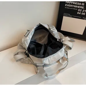 Silver wrinkled travel duffel bag with multiple inner compartments and sturdy grey handles.